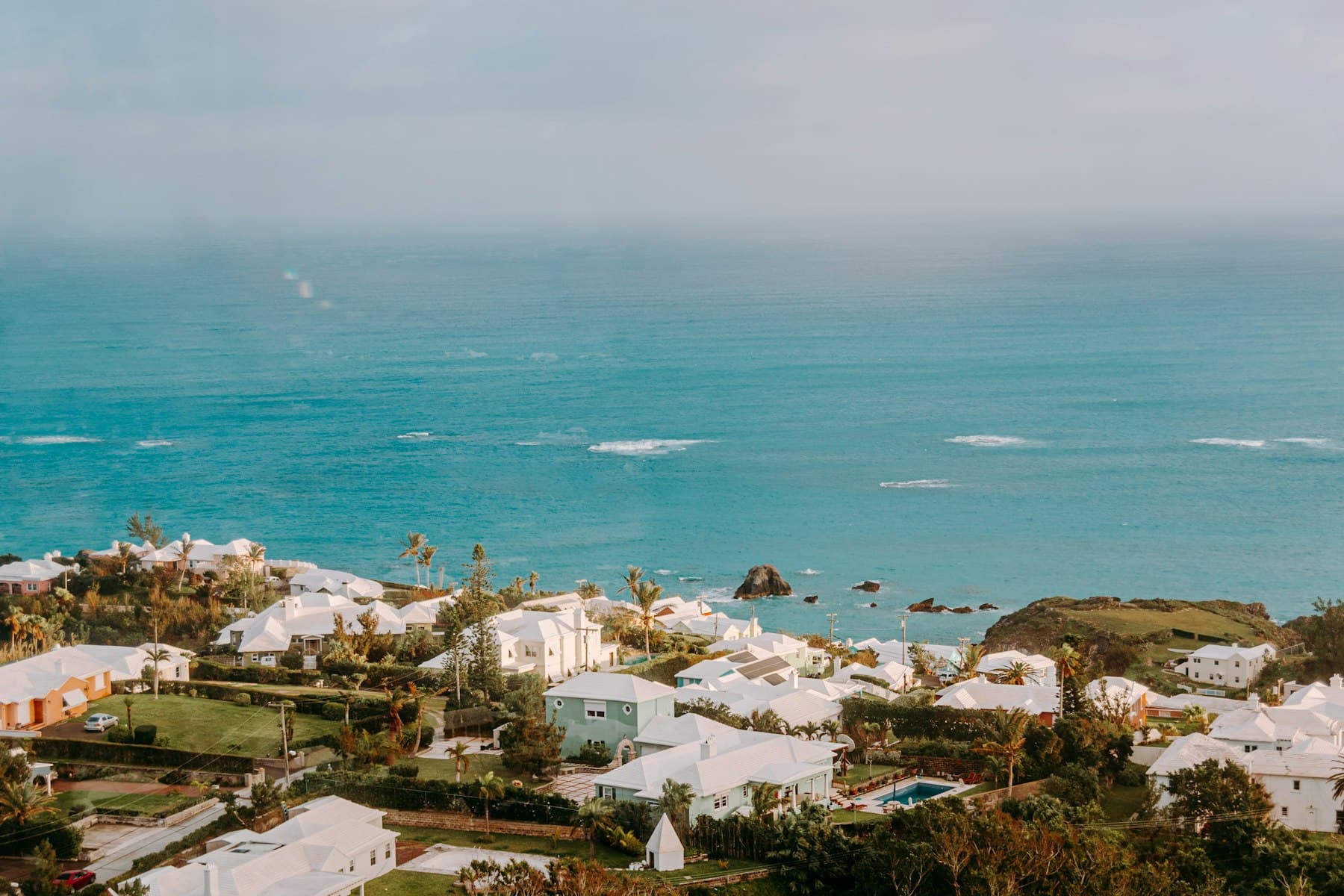 White stepped roofs of Bermudian houses running down to the sea
