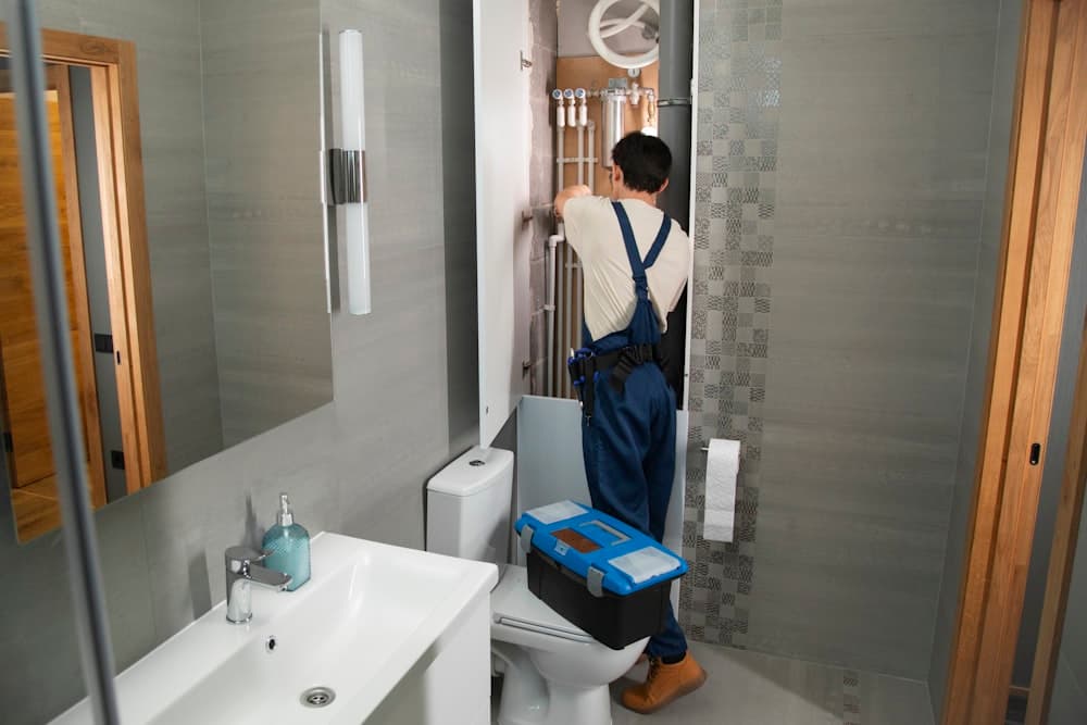Plumber working beneath a bathroom basin